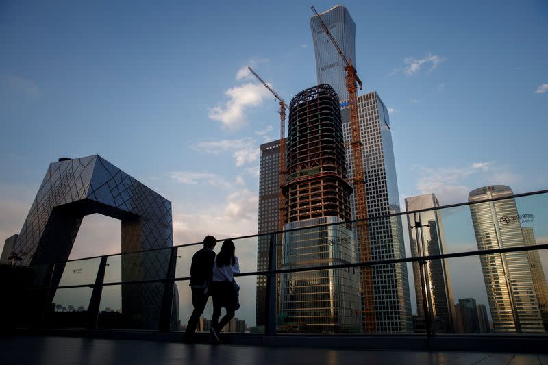 FILE PHOTO: People look at the skyline of the Central Business District in Beijing