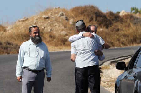 Israelis embrace near the scene where the Israeli military said an Israeli soldier was found stabbed to death near a Jewish settlement outside the Palestinian city of Hebron in the Israeli-occupied West Bank