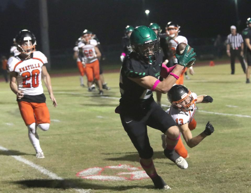 Father Lopez High's Dylan Tocci #22 grabs a short pass for a two pint conversion as the Umatilla defence gives chase, Friday night October 6, 2023 in Daytona Beach.