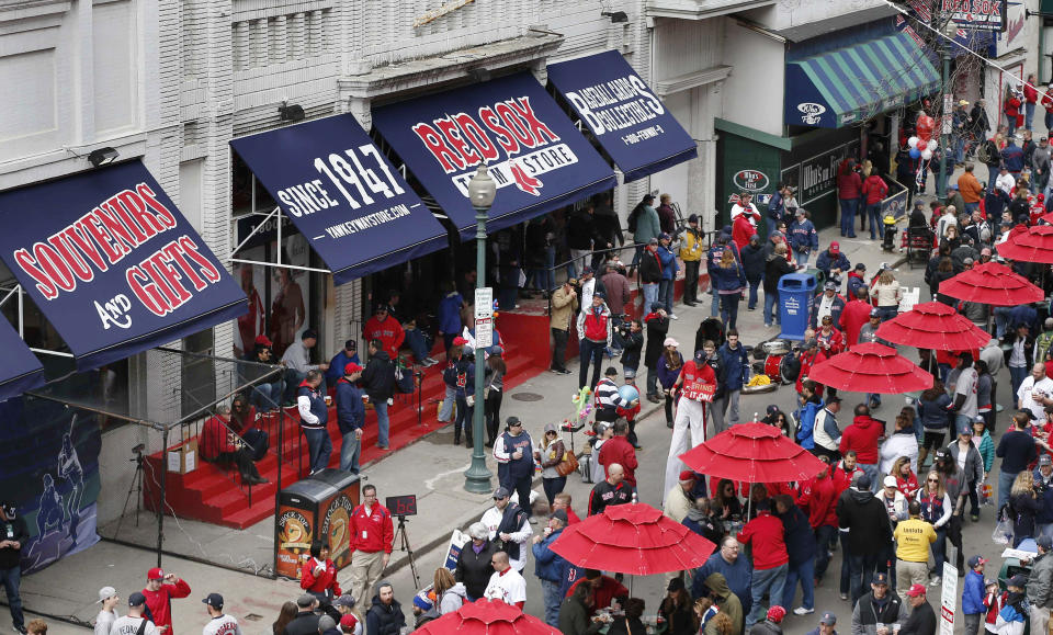 FILE - In this April 4, 2014 file photo, fans enjoy pre-game festivities outside Fenway Park in Boston. Ballpark area businesses are struggling during the 2020 season while fans are not in attendance due to the COVID-19 pandemic. (AP Photo/Michael Dwyer, File)