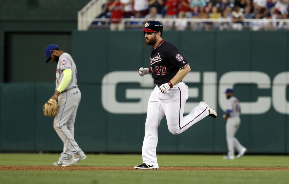 Washington Nationals' Daniel Murphy, center, rounds the bases past New York Mets shortstop Jose Reyes, left, on a three-run home run during the third inning of a baseball game at Nationals Park, Tuesday, July 31, 2018, in Washington. The Nationals won 25-4. (AP Photo/Alex Brandon)