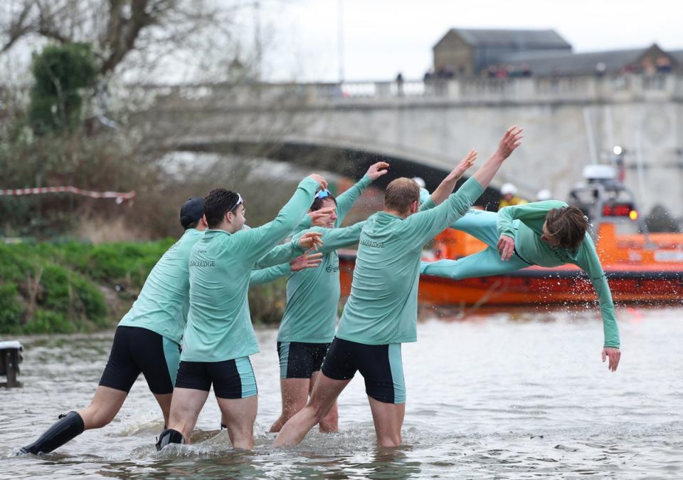 Cox Jasper Parish of Cambridge University Boat Club is thrown into the Thames by teammates (Getty)