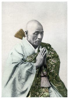 A vintage photograph of a Buddhist priest in repose.
