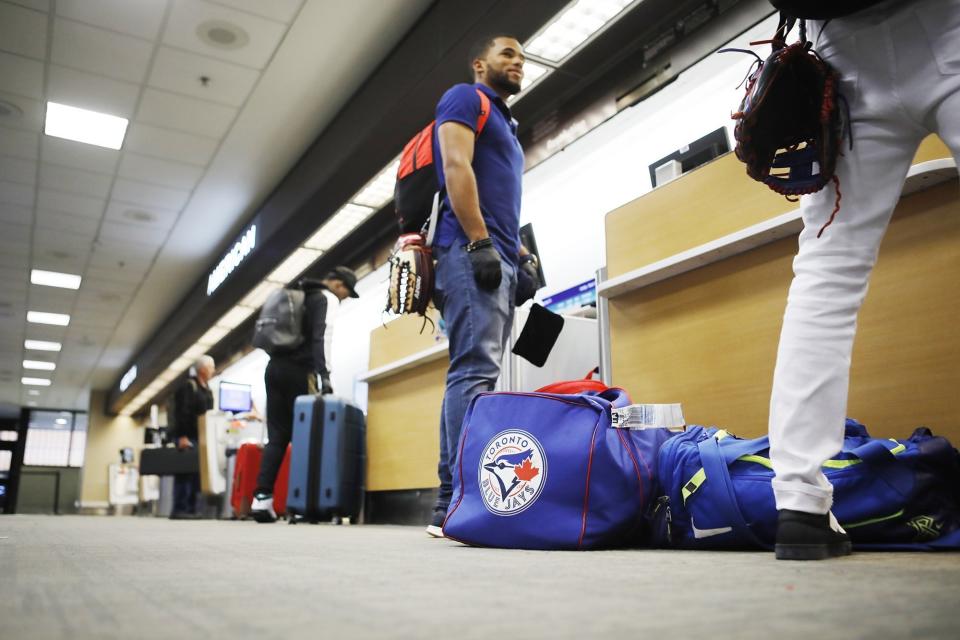 Toronto Blue Jays minor league baseball player Steward Berroa, center, prepares to fly home along with his teammates from the Dominican Republic at the Tampa International Airport in Tampa, Florida on Sunday, March 15, 2020. Flight schedules for departures and arrivals remain normal during the coronavirus pandemic.(Octavio Jones/Tampa Bay Times via AP)