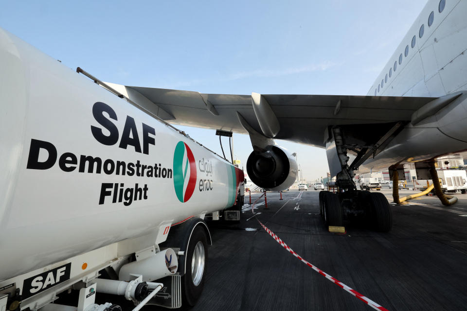 Ground crews prepare an Emirates Boeing 777-300ER aircraft, powering one of its engines with a hundred per cent Sustainable Aviation Fuel (SAF), for a demonstration flight at the Dubai International Airport in Dubai, on January 30, 2023. - Emirates said it successfully flew a Boeing 777 powered by sustainable aviation fuel today, as the Middle East's largest airline aims to halve its jet fuel consumption. The Dubai-based carrier has used sustainable aviation fuel (SAF) since 2017, but said its test flight was 