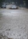 A car drives through deep water in a flooded street following heavy rainfall in Yalta