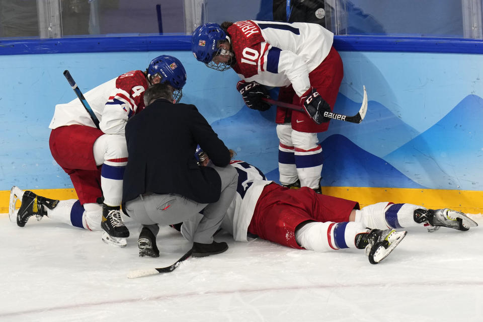 Czech Republic's Tereza Radova (27) is helped after being injured during a women's quarterfinal hockey game against the United States at the 2022 Winter Olympics, Friday, Feb. 11, 2022, in Beijing. (AP Photo/Petr David Josek)