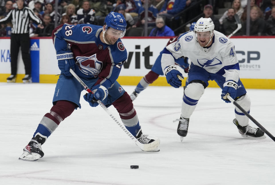 Colorado Avalanche left wing Miles Wood, left, drives past Tampa Bay Lightning defenseman Darren Raddysh in the first period of an NHL hockey game on Monday, Nov. 27, 2023, in Denver. (AP Photo/David Zalubowski)