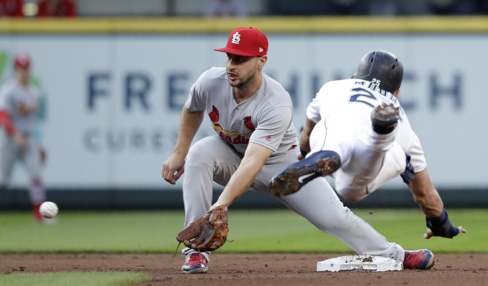 St. Louis Cardinals shortstop Paul DeJong, left, reaches for the ball before tagging out Seattle Mariners' Dylan Moore at second on a stolen-base attempt during the second inning of a baseball game Wednesday, July 3, 2019, in Seattle. (AP Photo/Elaine Thompson)