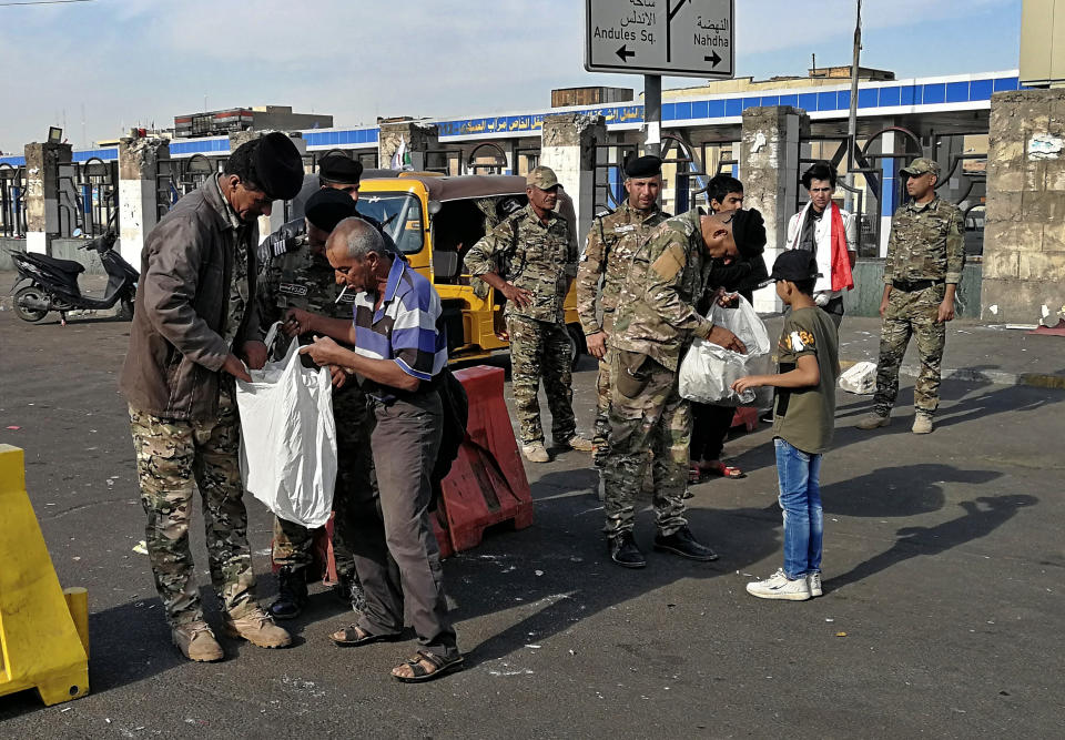 Security forces search people heading into Tahrir Square where anti-government protests have been ongoing in Baghdad, Iraq, Thursday, Nov. 7, 2019. (AP Photo/Khalid Mohammed)