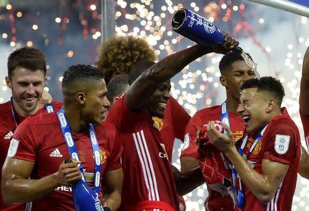 Britain Soccer Football - Southampton v Manchester United - EFL Cup Final - Wembley Stadium - 26/2/17 Manchester United's Eric Bailly pours champagne over Jesse Lingard as they celebrate winning the EFL Cup Final Reuters / Hannah McKay