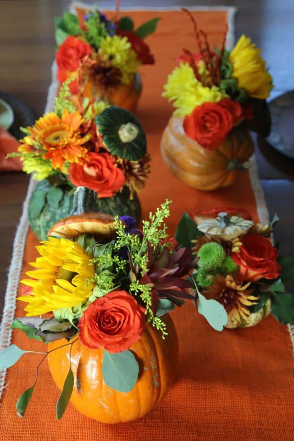 <p>No need to buy pumpkin vases when you can use the real thing! Cut a hole in the top of the pumpkin and remove the seeds like you would when carving, then fill with your favorite fall flower.</p><p><strong>Get the tutorial at <a rel="nofollow noopener" href="https://www.delicioustable.com/thanksgiving-table-pumpkin-flower-centerpieces/" target="_blank" data-ylk="slk:Delicious Table;elm:context_link;itc:0;sec:content-canvas" class="link ">Delicious Table</a>.</strong> </p>