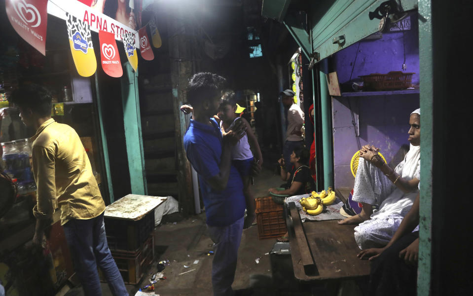 Izhaar Hussain Shaikh, center, an ambulance driver who works for HelpNow, an initiative to help the stretched services of first responders, kisses his son as his mother, right, looks on in a lane outside their house in a slum in Mumbai, India May 29, 2020. It’s an exhausting job and Shaikh's daily shifts are grueling, sometimes even stretching to 16 hours. For a city that has a history of shortage of ambulances and where coronavirus pandemic has claimed hundreds of lives, putting the health care system under immense strain, every help counts. (AP Photo/Rafiq Maqbool)