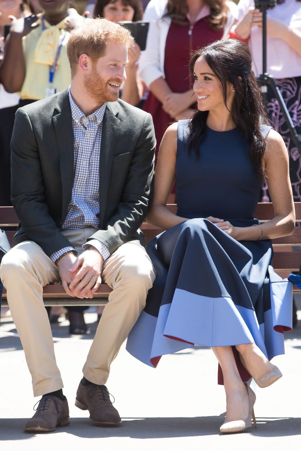 <p>Harry gazes at Meghan as she wears <a rel="nofollow noopener" href="https://www.net-a-porter.com/us/en/product/1091277/Roksanda/athena-pleated-two-tone-crepe-midi-dress?cm_mmc=LinkshareUK-_-TnL5HPStwNw-_-Custom-_-LinkBuilder&siteID=TnL5HPStwNw-2oF7kLeE13FGdxPo7PUoJw&Skimlinks.com=Skimlinks.com&dclid=CKzQ4I_Yl94CFQ_E3godeAMEnQ" target="_blank" data-ylk="slk:Roksanda's Athena pleated two-tone crepe midi dress;elm:context_link;itc:0;sec:content-canvas" class="link ">Roksanda's Athena pleated two-tone crepe midi dress</a>.</p>