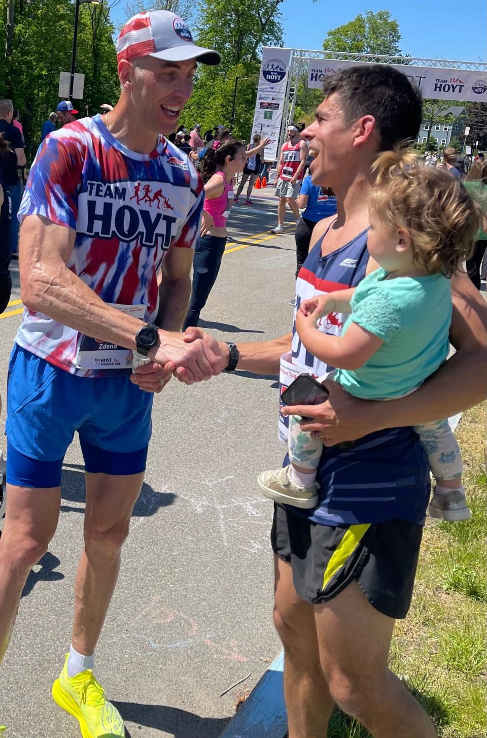 Former Boston Bruins captain Zdeno Chara greets a finisher at Saturday's Dick Hoyt Memorial Yes You Can road race in Hopkinton.