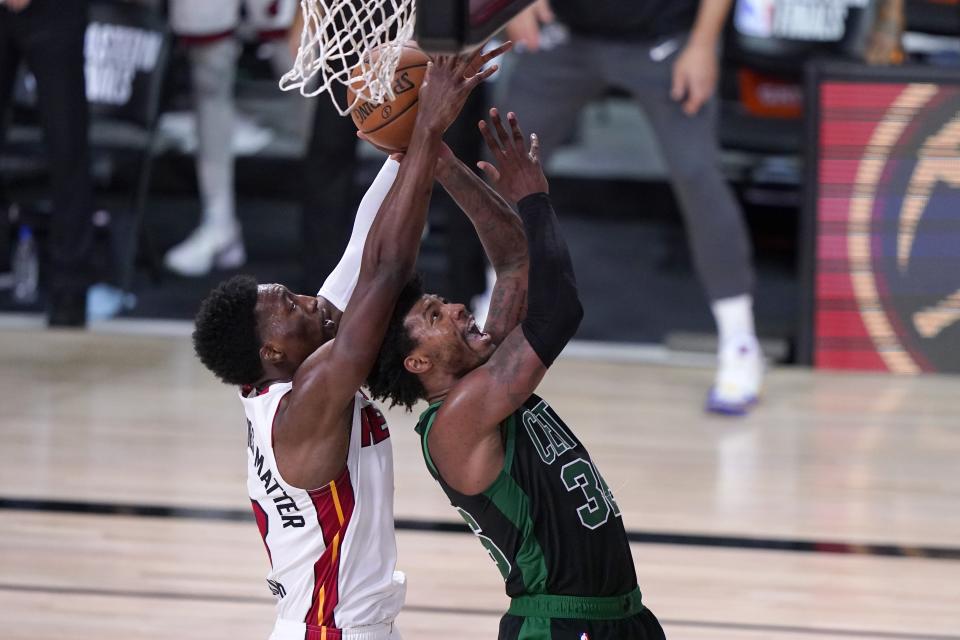 Miami Heat forward Bam Adebayo, left, contest a shot by Boston Celtics guard Marcus Smart, right, during the second half of an NBA conference final playoff basketball game, Thursday, Sept. 17, 2020, in Lake Buena Vista, Fla. (AP Photo/Mark J. Terrill)