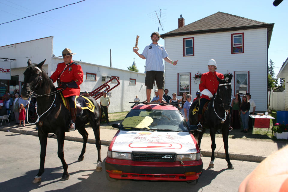 MacDonald stands atop a car during his housewarming party in Kipling, Saskatchewan, in 2006. Hundreds of people attended. (Courtesy Kyle MacDonald)