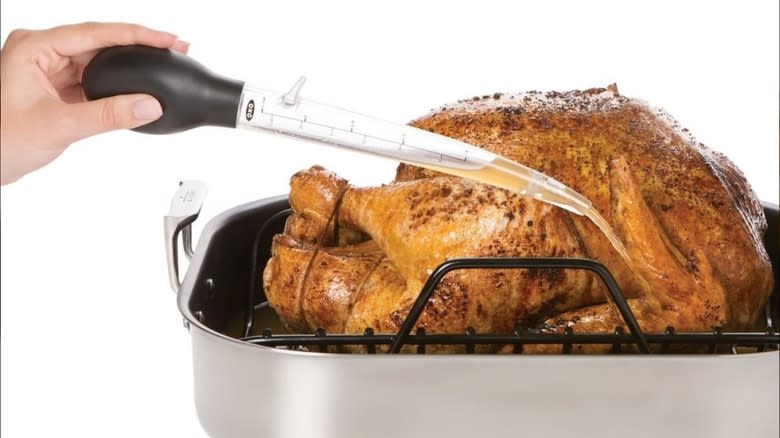 hand holding angled turkey baster