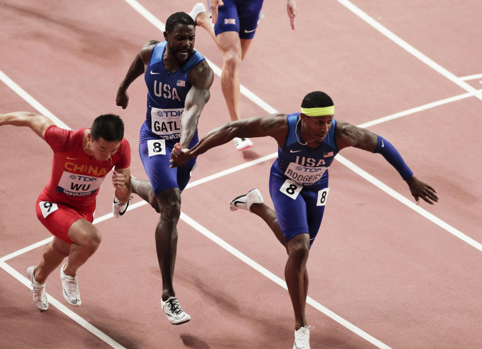 Justin Gatlin of the United States, center, passes the baton to Michael Rodgers in the men's 4x100 meter relay final at the World Athletics Championships in Doha, Qatar, Saturday, Oct. 5, 2019. (AP Photo/Nariman El-Mofty)