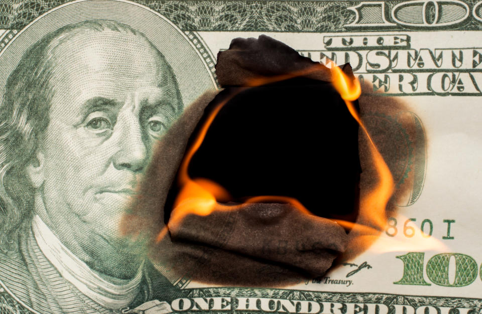A one hundred dollar bill burning from the center outwards.