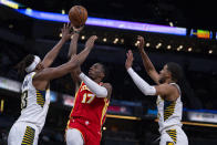 Atlanta Hawks forward Onyeka Okongwu (17) shoots between Indiana Pacers center Myles Turner (33) and guard Tyrese Haliburton (0) during the first half of an NBA preseason basketball game in Indianapolis, Monday, Oct. 16, 2023. (AP Photo/Michael Conroy)