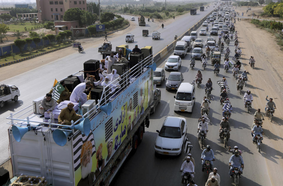 A caravan of supporters of the Jamiat Ulema-e-Islam party head to capital Islamabad during an anti-government march, in Karachi, Pakistan, Sunday, Oct. 27, 2019. Thousands of supporters of the ultra-religious party led by a firebrand cleric have started their large anti-government march on Pakistan's capital farther north. (AP Photo/Fareed Khan)