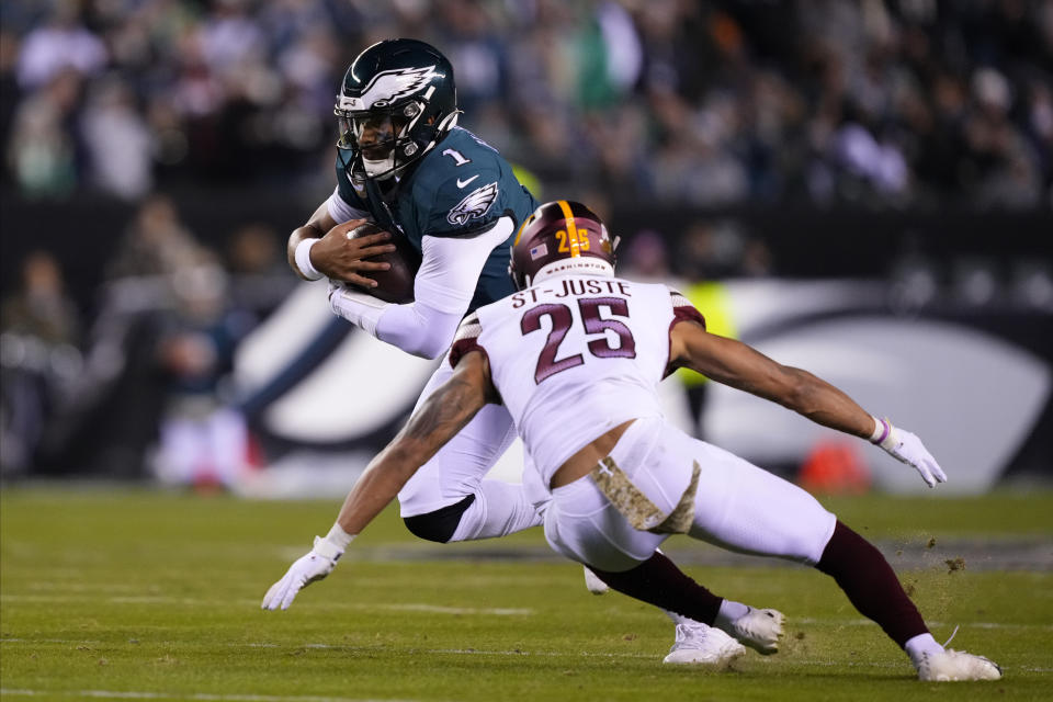 Philadelphia Eagles quarterback Jalen Hurts (1) runs against Washington Commanders cornerback Benjamin St-Juste (25) during the second half of an NFL football game, Monday, Nov. 14, 2022, in Philadelphia. (AP Photo/Matt Rourke)