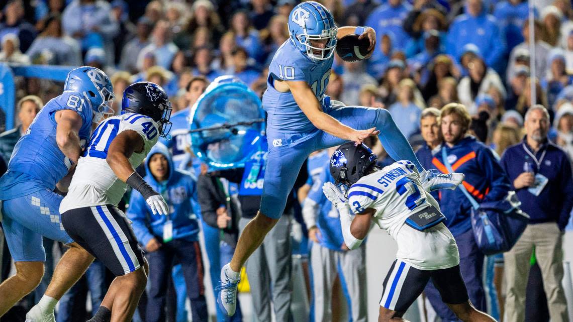 North Carolina quarterback Drake Maye (10) picks up 15-yards as he hurdles over Duke’s Jaylen Stinson (2) to set up a touchdown in the third quarter on Saturday, Nov. 11, 2023 at Kenan Stadium in Chapel Hill, N.C.