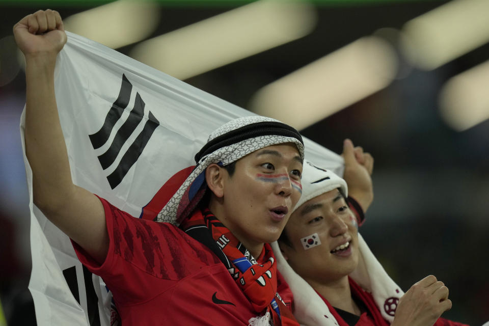 En esta imagen de archivo, aficionados surcoreanos esperan el inicio del partido del Grupo H del Mundial entre Corea del Sur y Portugal, en el estadio Education City, en Rayán, Qatar, el 2 de diciembre de 2022. En un Mundial marcado por la controversia en lo político, no sorprende que el estilo de los aficionados haya suscitado polémica. En la primera Copa del Mundo que se celebra en Oriente Medio, aficionados de todo el mundo han reinterpretado los tocados y túnicas tradicionales de los países del Golfo Pérsico. (AP Foto/Francisco Seco, archivo)