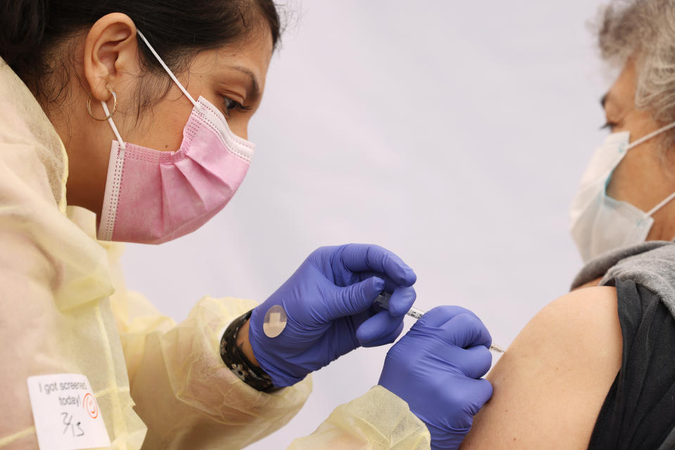 LOS ANGELES, CA - FEBRUARY 13: Evelin Nunez, left, gives Francisca Kelley, right, the Pfizer vaccine during an event to inoculate about 500 health care workers and adults over the age of 65 against COVID-19 put on by the Labor Community Services, the Los Angeles Federation of Labor and St. Johns Well Child and Family Center coined Labor of Love, in Pico Union on Saturday, Feb. 13, 2021 in Los Angeles, CA. People will be welcomed back in three weeks to receive their second dose. (Dania Maxwell / Los Angeles Times via Getty Images)