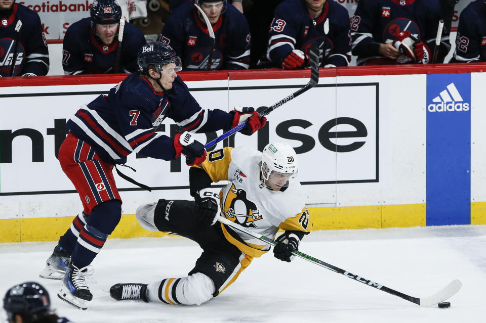 Winnipeg Jets' Vladislav Namestnikov (7) and Pittsburgh Penguins' Lars Eller (20) collide during the second period of an NHL hockey game Saturday, Feb. 10, 2024, in Winnipeg, Manitoba. (John Woods/The Canadian Press via AP)