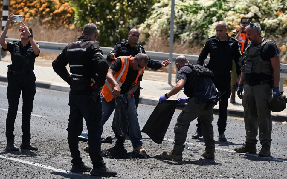 Israeli police and officials at the scene of Hezbollah projectile impacts in Nahariya, northern Israel