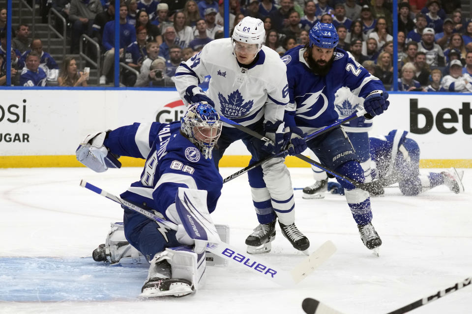 Tampa Bay Lightning goaltender Andrei Vasilevskiy (88) makes a pad save as Toronto Maple Leafs center David Kampf (64) looks for a rebound during the first period in Game 6 of an NHL hockey Stanley Cup first-round playoff series Saturday, April 29, 2023, in Tampa, Fla. Looking on is defenseman Zach Bogosian (24). (AP Photo/Chris O'Meara)