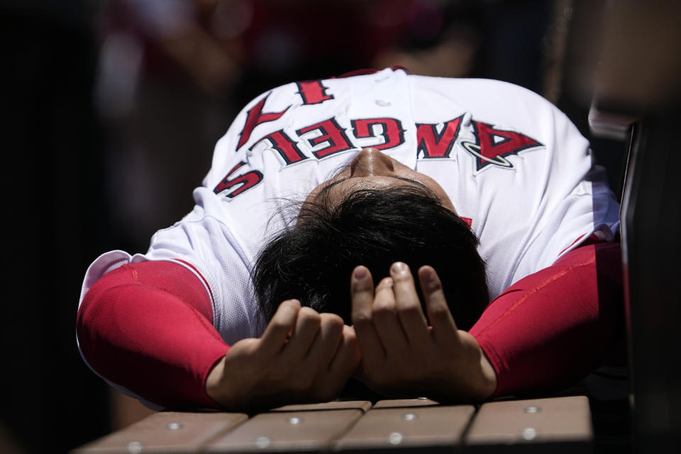 Los Angeles Angels' Shohei Ohtani lays on a bench in the dugout prior to a baseball game against the Arizona Diamondbacks Sunday, July 2, 2023, in Anaheim, Calif. (AP Photo/Mark J. Terrill)