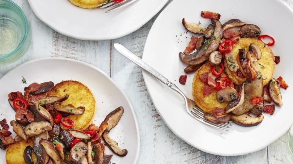 polenta cakes with sautéed mushrooms on three plates with forks