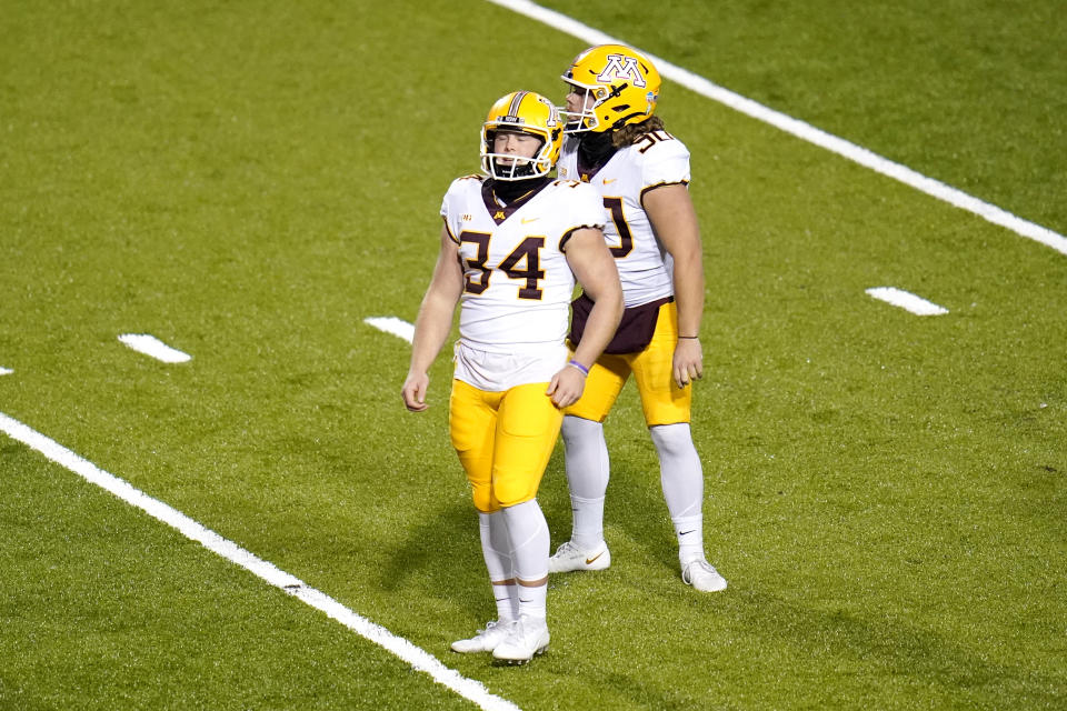 Minnesota place kicker Brock Walker, left, reacts after missing an extra point kick during overtime of an NCAA college football game against Maryland, Friday, Oct. 30, 2020, in College Park, Md. Maryland won 45-44 in overtime. (AP Photo/Julio Cortez)