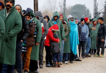 A stranded Iranian woman embraces her daughter as hundreds of migrants line up during food distribution at the Greek-Macedonian border, near the Greek village of Idomeni November 25, 2015. REUTERS/Yannis Behrakis