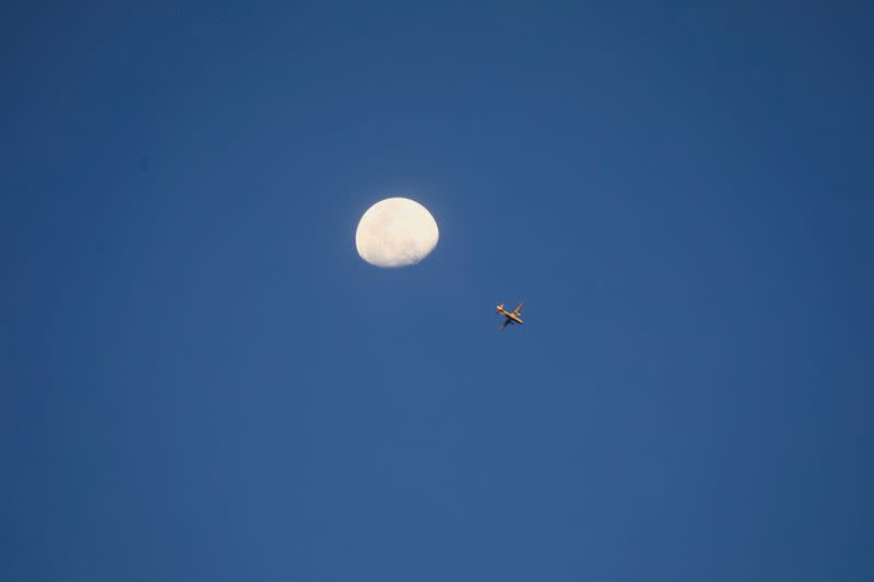 FILE PHOTO: View of the moon while a strike aircraft prepares for an aerial bombardment in Khartoum