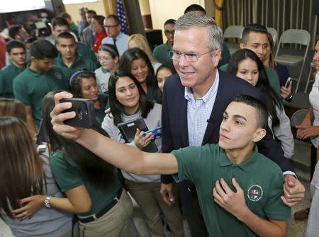 Former Florida Governor and Republican candidate for president Jeb Bush poses with a student following a town hall with high school students at La Progresiva Presbyterian School in Miami, Florida, September 1, 2015. REUTERS/Joe Skipper