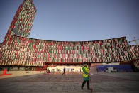 A municipal worker sweeps the pavement as a red carpet is installed outside the venue of the EU Western Balkans Summit, in Tirana, Albania, Monday, Dec. 5, 2022. As the war in Ukraine has put the bloc's enlargement back at the top of the agenda, Albania hosts in Tirana leaders of the EU and the Western Balkans countries for a one-day summit aimed at reinvigorating the bloc's enlargement process. (AP Photo/Vadim Ghirda)