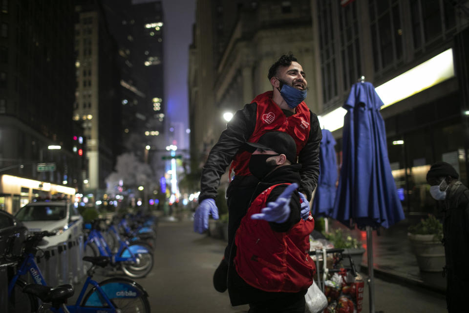 Mohammed Widdi, 31, coordinator of Muslims Giving Back, bottom, and Soubhi Khalil, 25, both volunteers with Muslims Giving Back, celebrate after successfully handing out food to the hungry in Herald Square in New York, on Sunday, April 26, 2020. (AP Photo/Wong Maye-E)