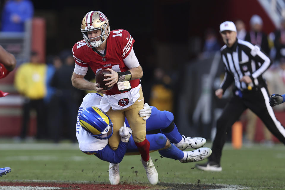 San Francisco 49ers quarterback Sam Darnold (14) is tackled by Los Angeles Rams linebacker Michael Hoecht during the second half of an NFL football game in Santa Clara, Calif., Sunday, Jan. 7, 2024. (AP Photo/Jed Jacobsohn)