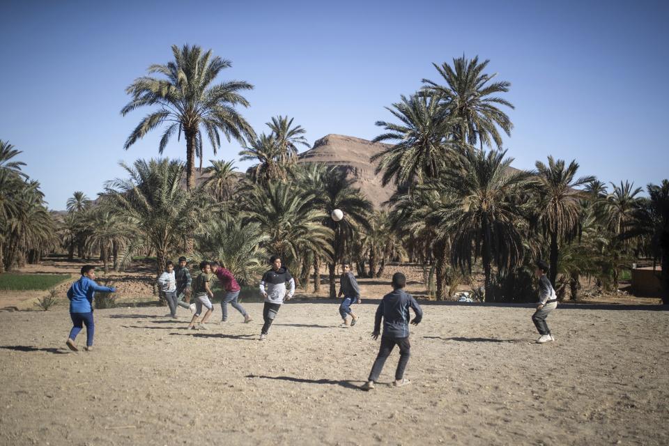 Boys play football in the Alnif oasis town, near Tinghir, Morocco, Tuesday, Nov. 29, 2022. The centuries-old oases that have been a trademark of Morocco are under threat from climate change, which has created an emergency for the kingdom's agriculture. (AP Photo/Mosa'ab Elshamy)