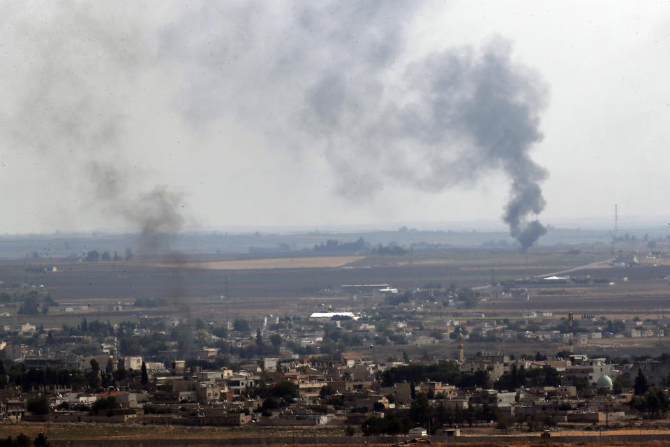 In this photo taken from the Turkish side of the border between Turkey and Syria, in Ceylanpinar, Sanliurfa province, southeastern Turkey, smoke billows from fires in Ras al-Ayn, Syria, Sunday, Oct. 20, 2019. Turkey's defense ministry says one soldier has been killed amid sporadic clashes with Kurdish fighters in northern Syria, despite a U.S.-brokered cease-fire. The ministry also said it allowed a 39-vehicle humanitarian convoy to enter Ras al-Ayn, a key border town that's seen some of the heaviest fighting. (AP Photo/Lefteris Pitarakis)