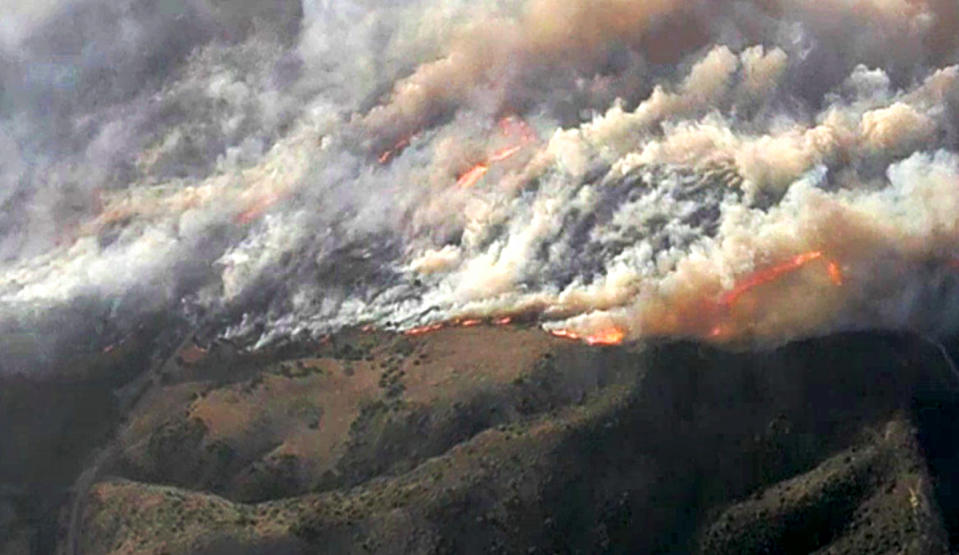 This photo from video provided by KNBC-TV shows smoke and flames from the Silverado fire that is threatening areas near Irvine in Southern California's Orange County Monday, Oct. 26, 2020. Driven by strong, gusting winds, the fire grew rapidly Mondy morning. (KNBC-TV via AP)