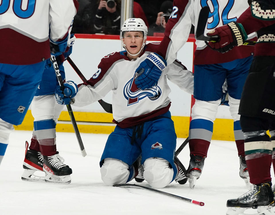 On his knees, Colorado Avalanche's Nathan MacKinnon (29) celebrates his goal against the Arizona Coyotes during the first period of an NHL hockey game Saturday, Jan. 15, 2022, in Glendale, Ariz. (AP Photo/Darryl Webb)