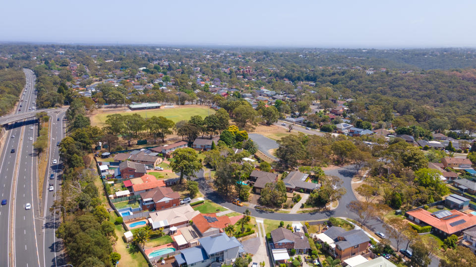 Aerial drone view of homes and streets above Bangor in the Sutherland Shire, south Sydney, NSW Australia showing Bangor Bypass in the background.