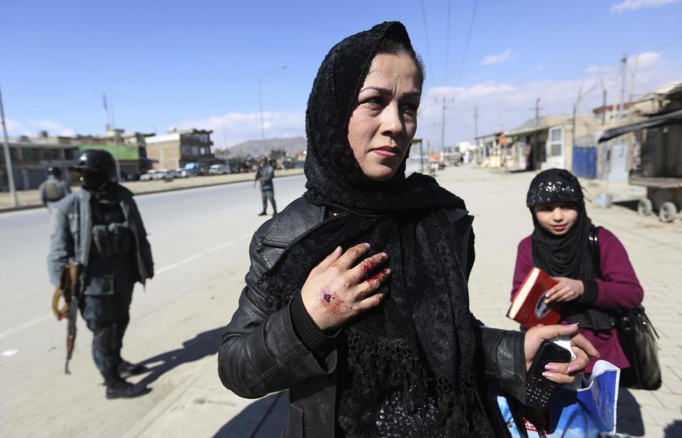 An injured Afghan woman police speaks with Media after a suicide attack in Kabul, Afghanistan, Wednesday, March 1, 2017. A pair of suicide bombings, both claimed by the Taliban, struck the Afghan capital, an Afghan official said. (AP Photo/Rahmat Gul)