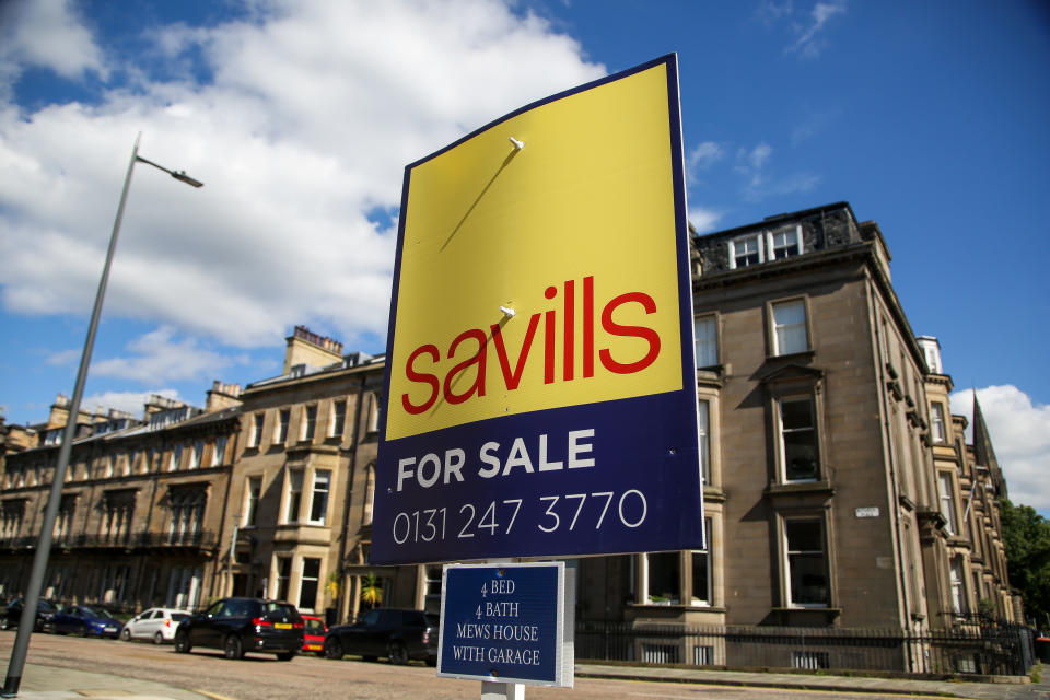 A 'For Sale' Savills estate agent board sign outside properties in Edinburgh