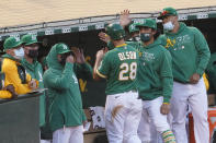 Oakland Athletics' Matt Olson (28) is congratulated by teammates after scoring a run against the Minnesota Twins during the fourth inning of the second baseball game of a doubleheader in Oakland, Calif., Tuesday, April 20, 2021. (AP Photo/Jeff Chiu)